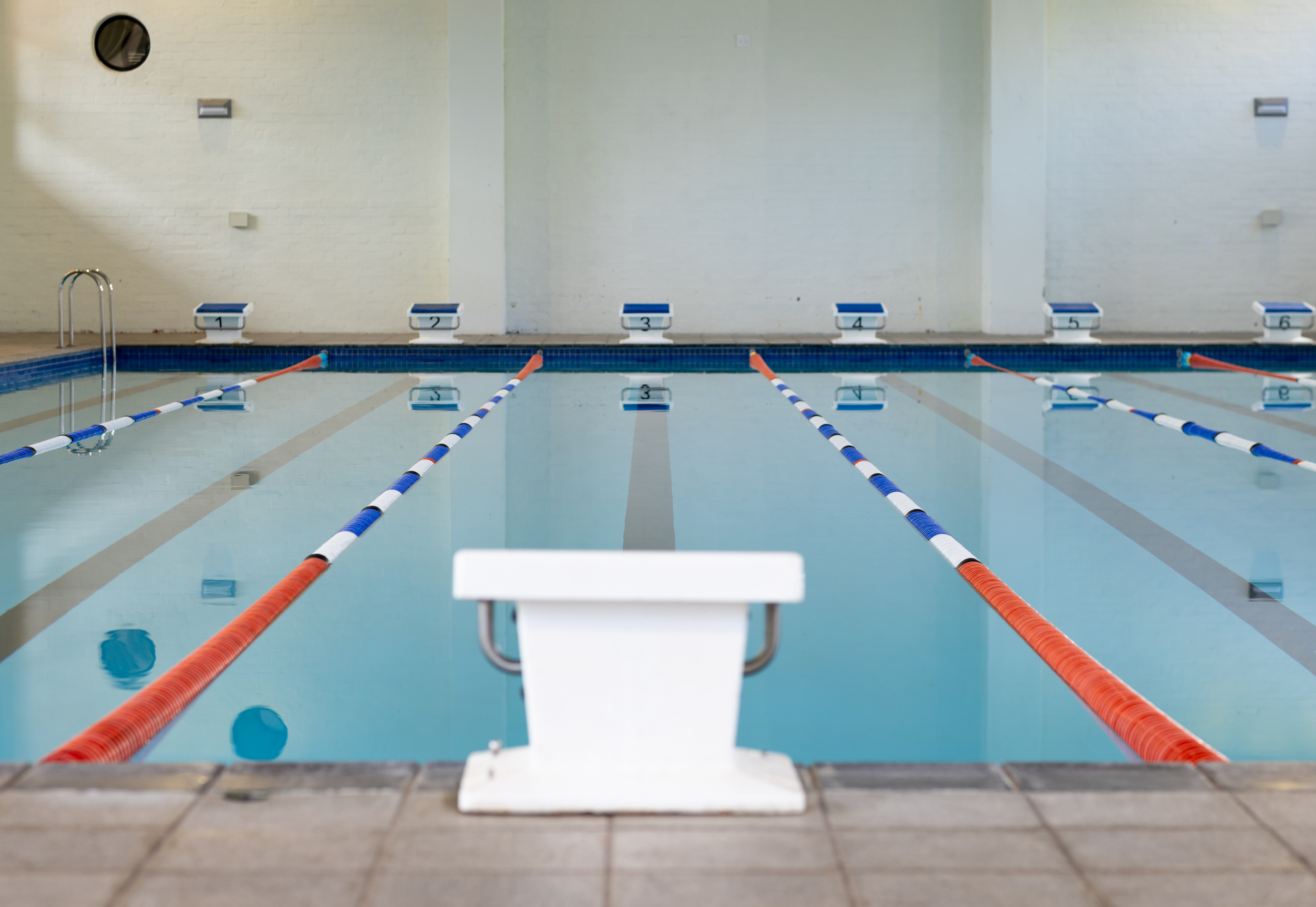 Im Vordergrund ein Startblock, dahinter die Bahnen eines Schwimmbeckens