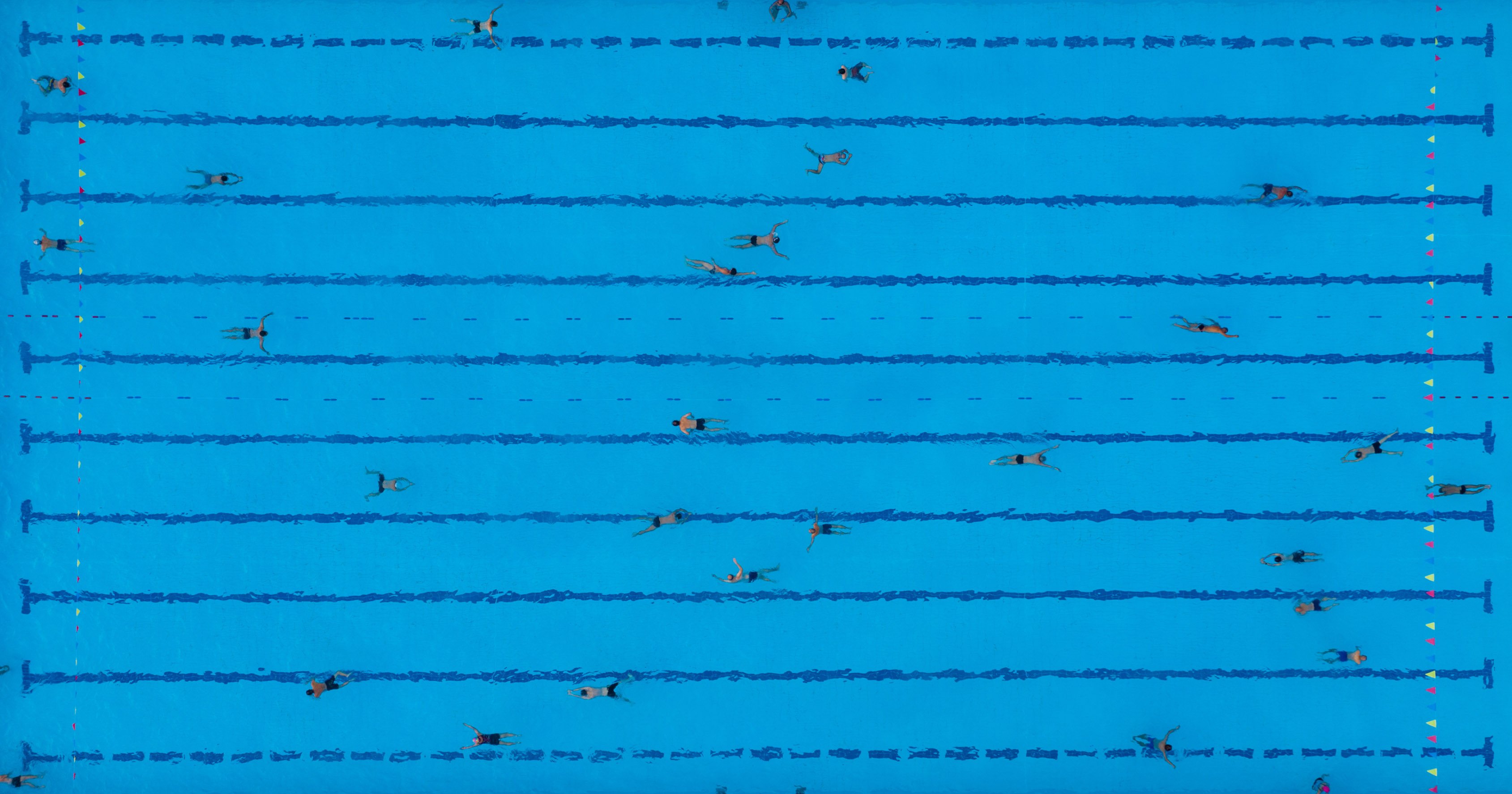 Viele Schwimmer:innen in einem großen Pool